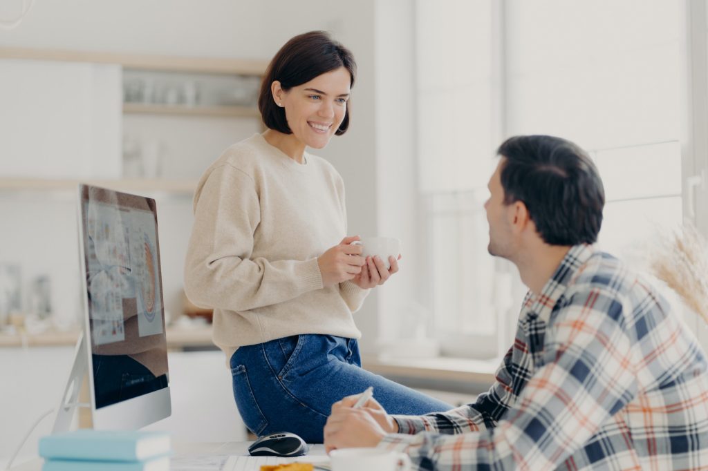 Family couple discusses making future investments, pose in coworking space, work on modern computer